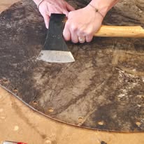 Découpe de la peau à la hachette sur le cadre, à l'atelier